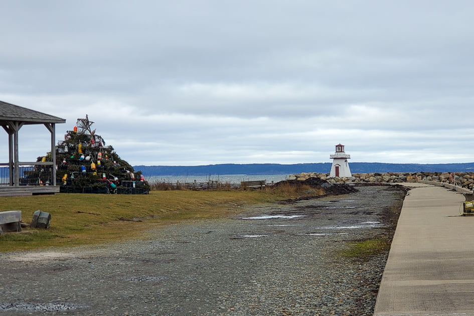 Lighthouse and Christmas tree made of lobster traps on Acadian shore in January