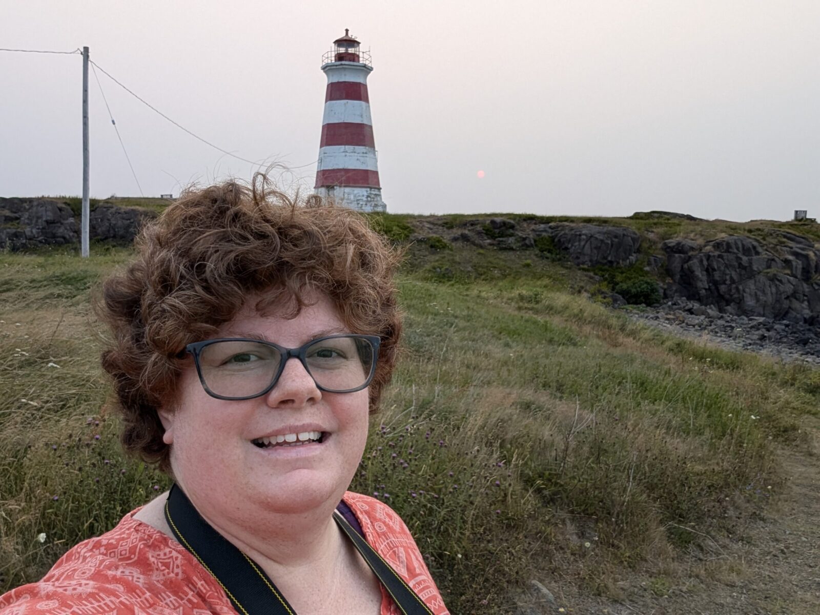 Nancy, the owner of Rediscover Nova Scotia in front of a Brier Island Lighthouse.