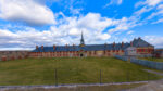 Wide view of the King’s Bastion barracks inside the Fortress of Louisbourg National Historic Site in Nova Scotia under a blue sky.