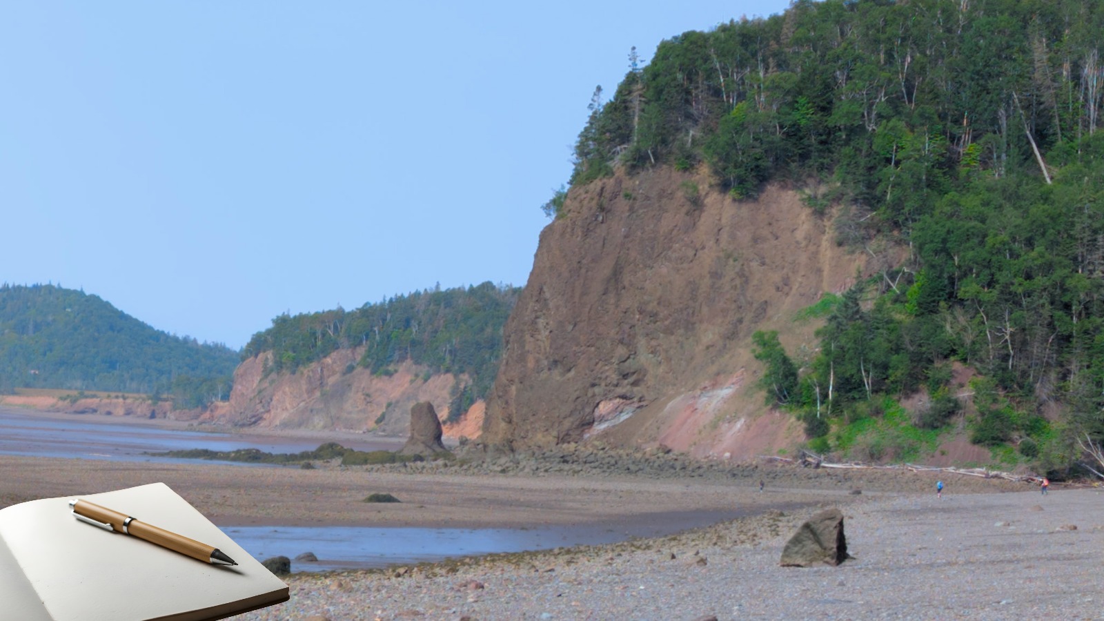 Open travel journal overlooking coastal cliffs in Nova Scotia